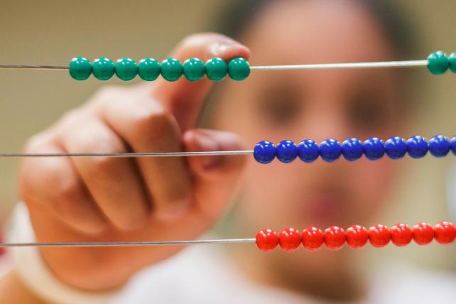 Childs hand moving abacus beads