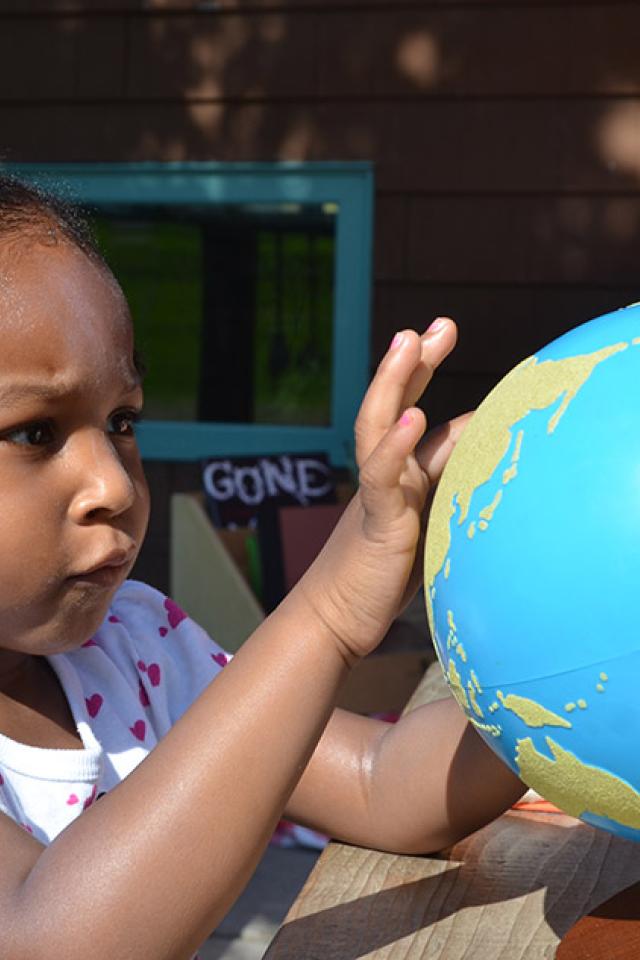 Child looking at world globe